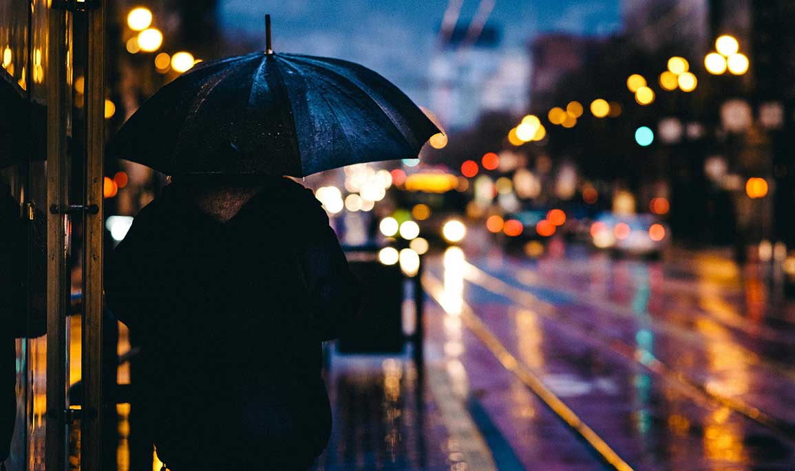 person in the street at night with an umbrella